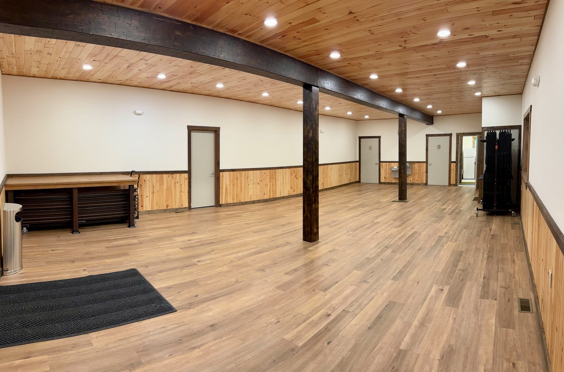 Main hall panoramic view showing wood-beam ceiling and hardwood floors